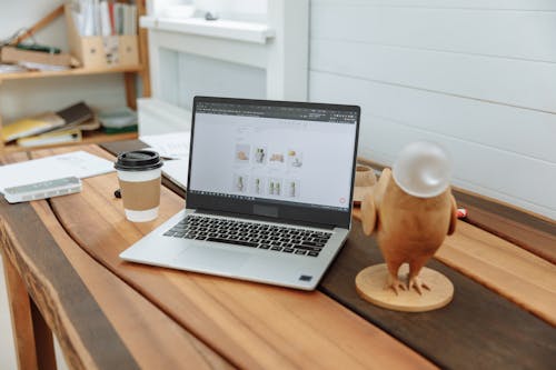 Free Laptop on a Wooden Table with the Design Business Website on the Screen Stock Photo