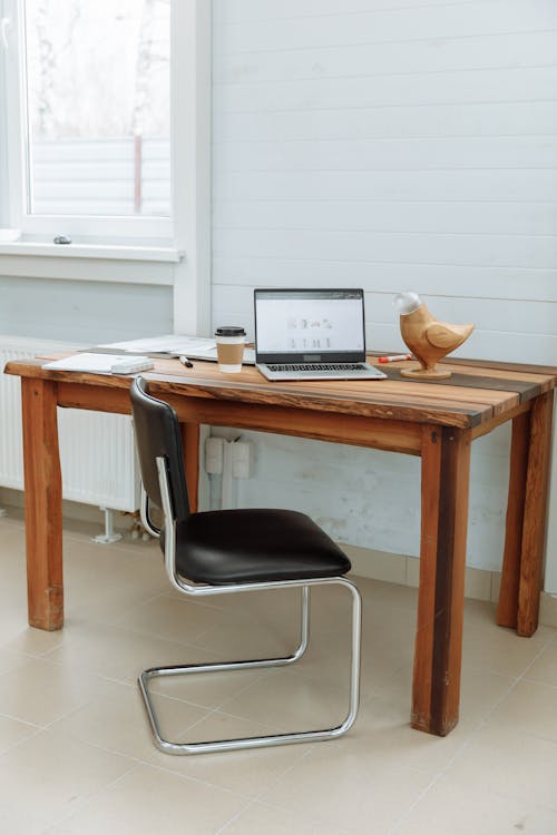 Free Computer on a Wooden Desk with the Designer's Business Website on the Screen Stock Photo