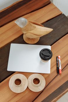 A minimalist wooden bird figurine perfect for creative spaces, accompanied by office essentials.