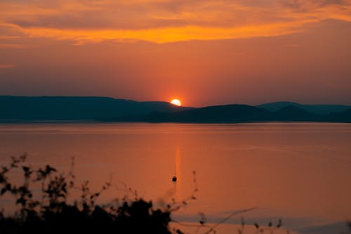 Free Silhouette of Mountain and Body of Water during Sunset Stock Photo