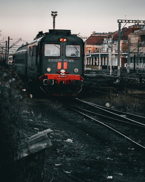 Free A vintage train arriving at a railway station during dusk, showcasing urban transit. Stock Photo