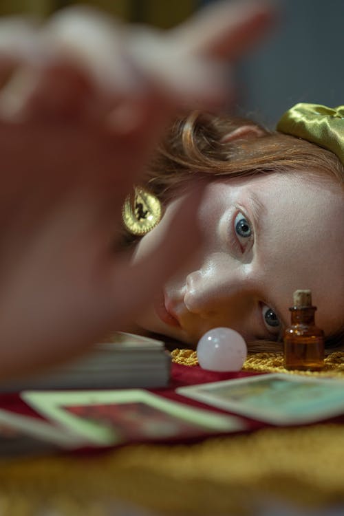 Woman Lying on Yellow Blanket Beside Cards