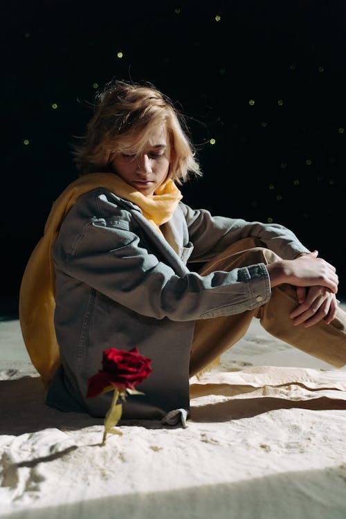 Boy with Yellow Scarf Looking at a Red Flower