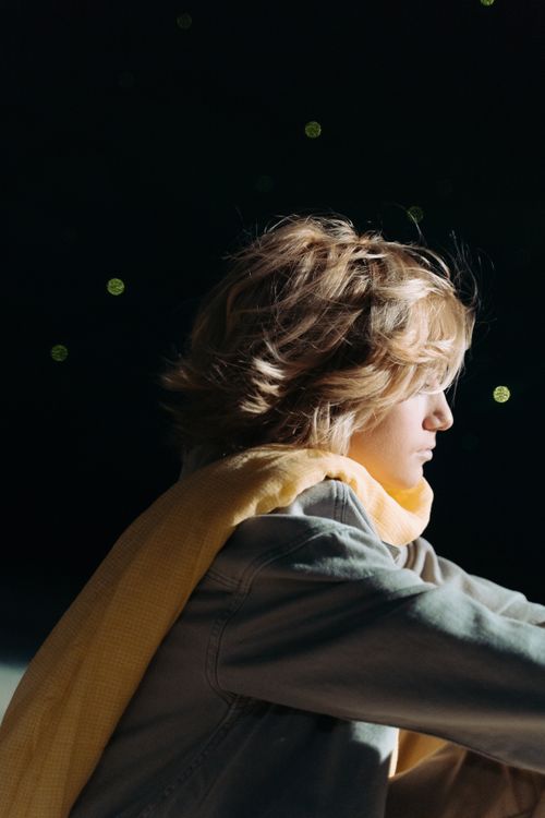 Free Profile of a young child wearing a yellow scarf under a starry night sky, evoking a whimsical, storybook feel. Stock Photo