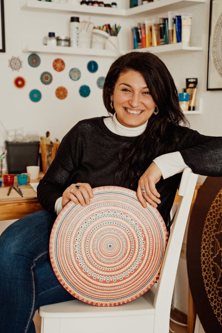 A Smiling Woman Holding A Colorful Round Object