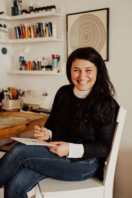 Woman in Black Long Sleeve Shirt Sitting on Chair