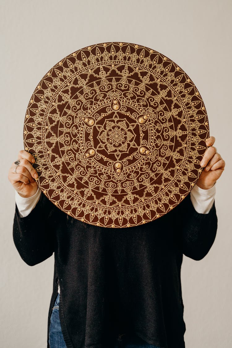 Person Holding Brown And Gold Mandala Decor