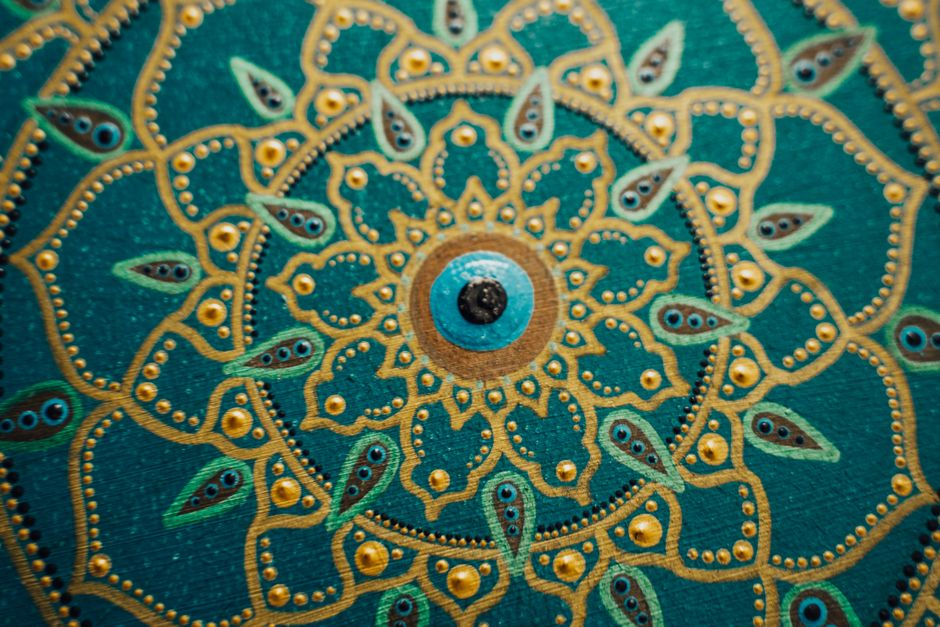 Detailed mandala artwork featuring gold and teal patterns showcasing symmetry