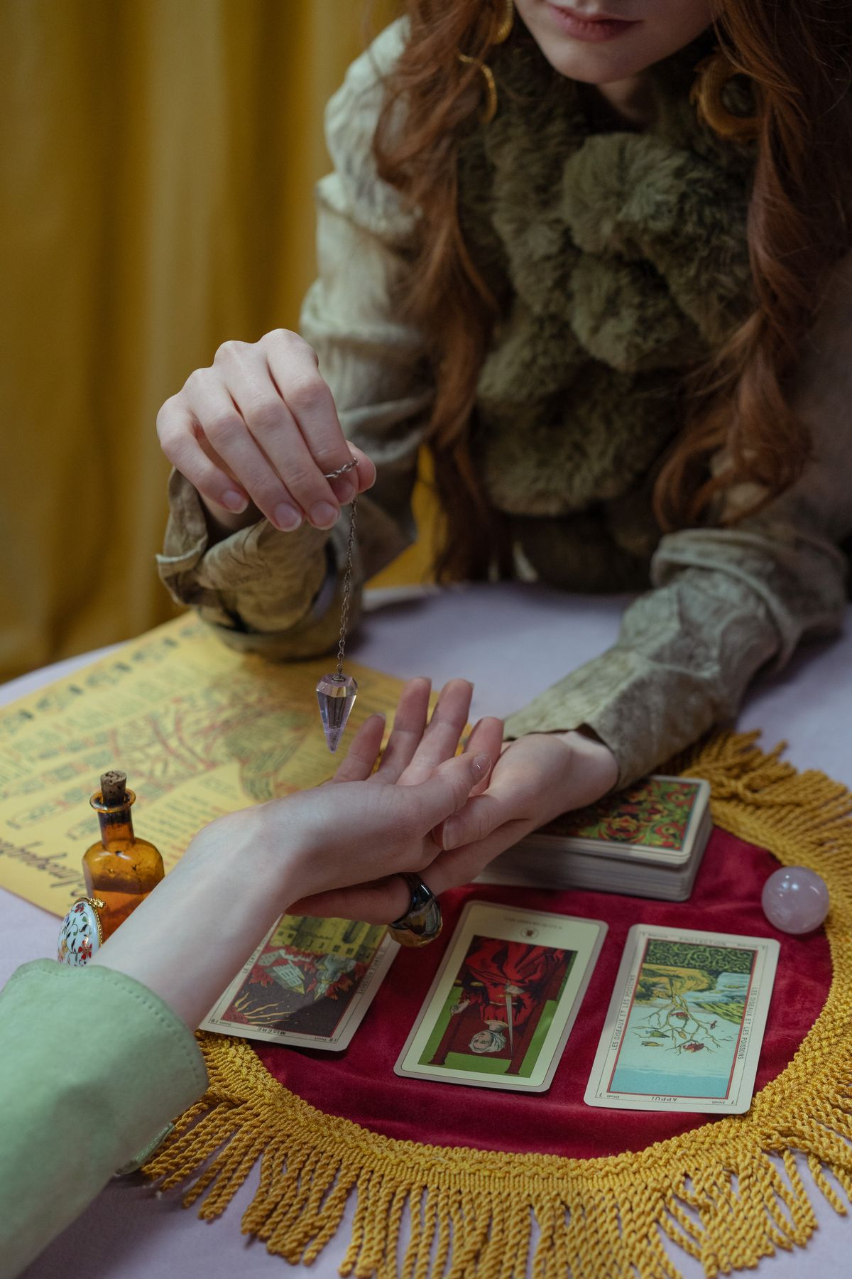 Astrologer reading tarot cards while holding a client's hand