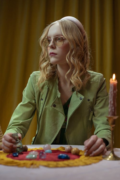 Woman in Green Coat Holding a Lighted Candle