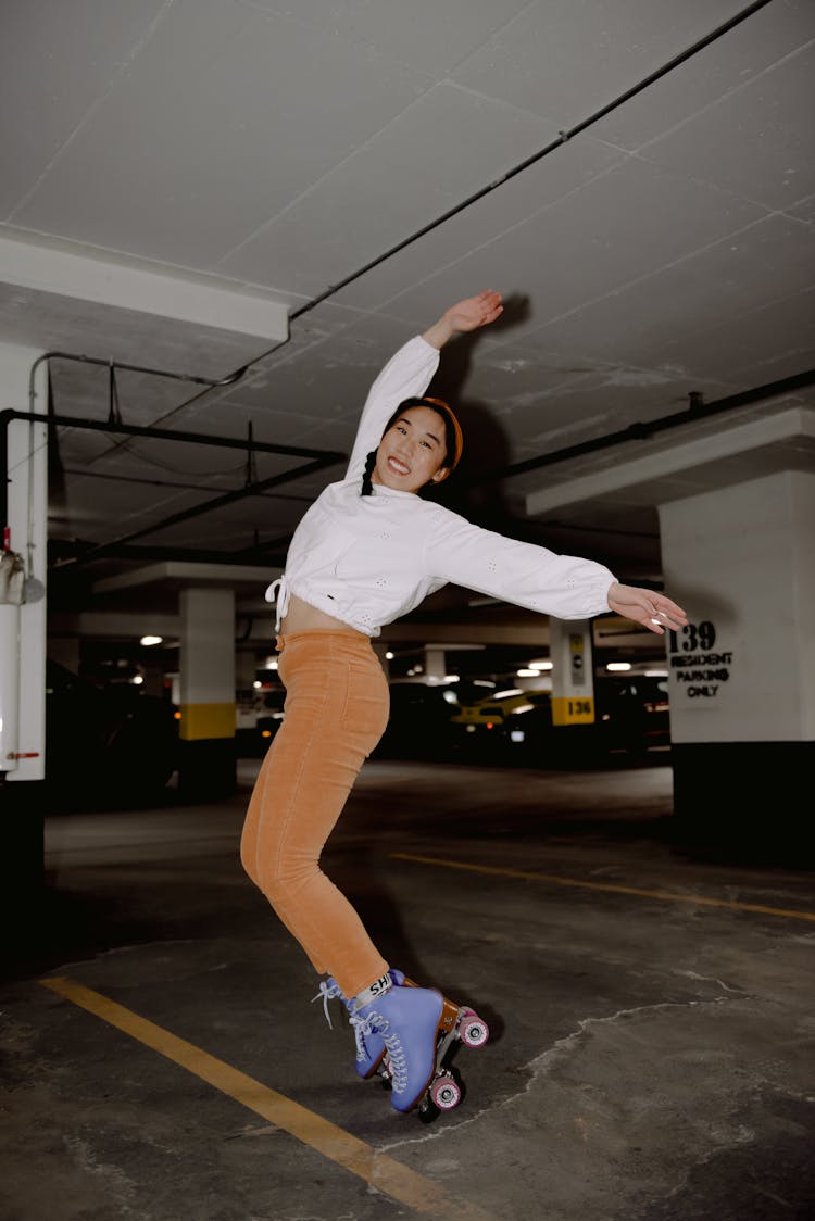 Smiling Asian Roller Skater On Tiptoes In Parking Lot