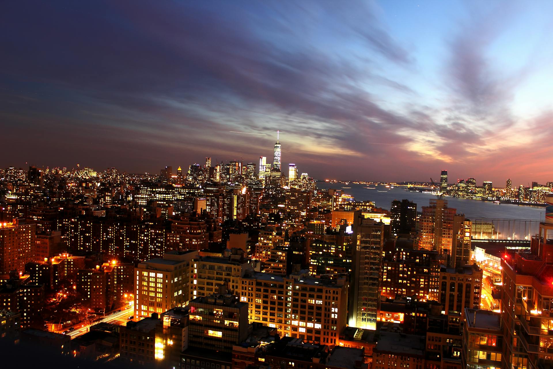 Breathtaking view of New York City's illuminated skyline during dusk, showcasing vibrant city lights.