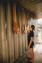 Sportswoman choosing wooden canoe oar in construction