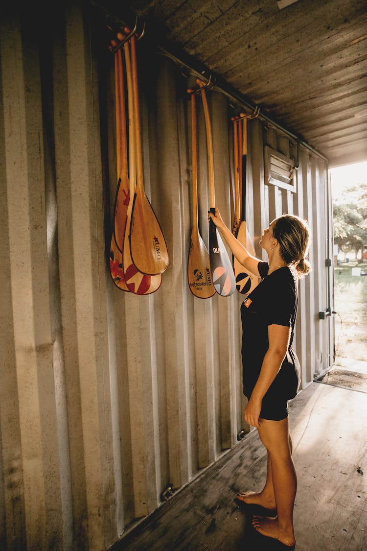 Sportswoman Choosing Wooden Canoe Oar In Construction