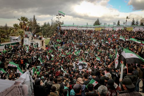 Free Large crowd gathers in Idlib for a protest, waving Syrian flags and expressing activism. Stock Photo