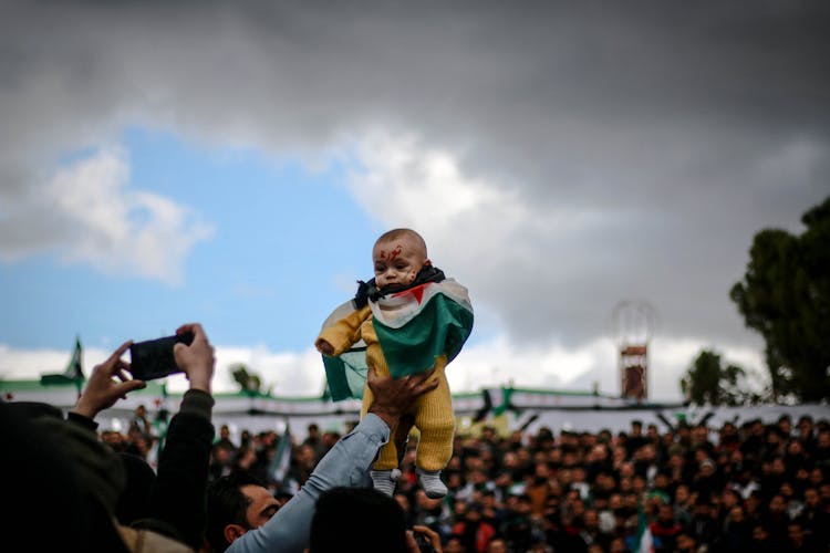 Baby In Flag In Air At Protest