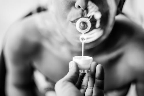 Free Grayscale Photo of a Person Blowing Bubbles Stock Photo