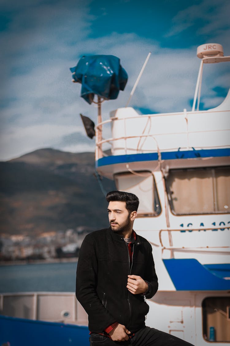 A Man In Black Jacket Riding A Boat