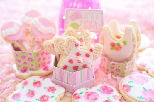 A delightful display of pink decorated cookies for a baby girl shower celebration.