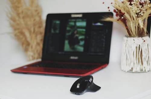 Free A Wireless Mouse Beside a Laptop Stock Photo