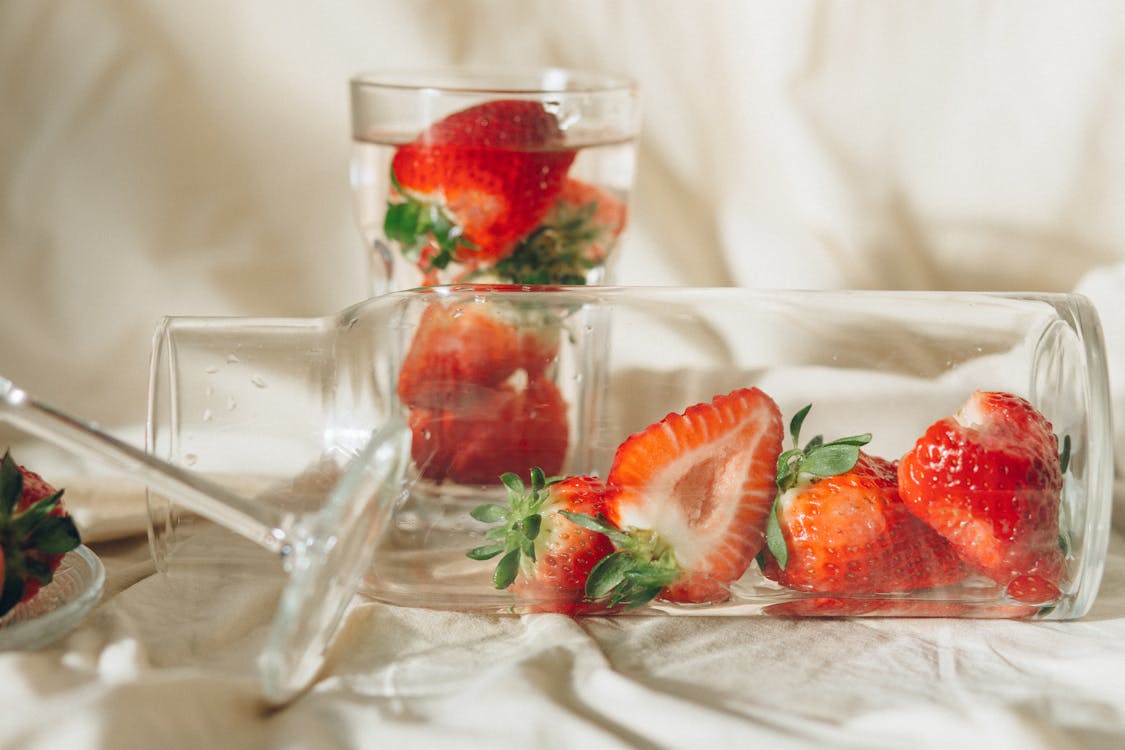 Close-Up Photo of Sliced Strawberries in Clear Glass Jar