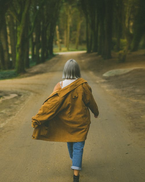Free Woman Walking into the Forest Stock Photo