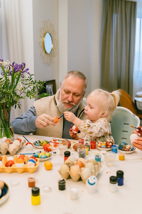 Grandfather and Granddaughter Painting Easter Eggs Together