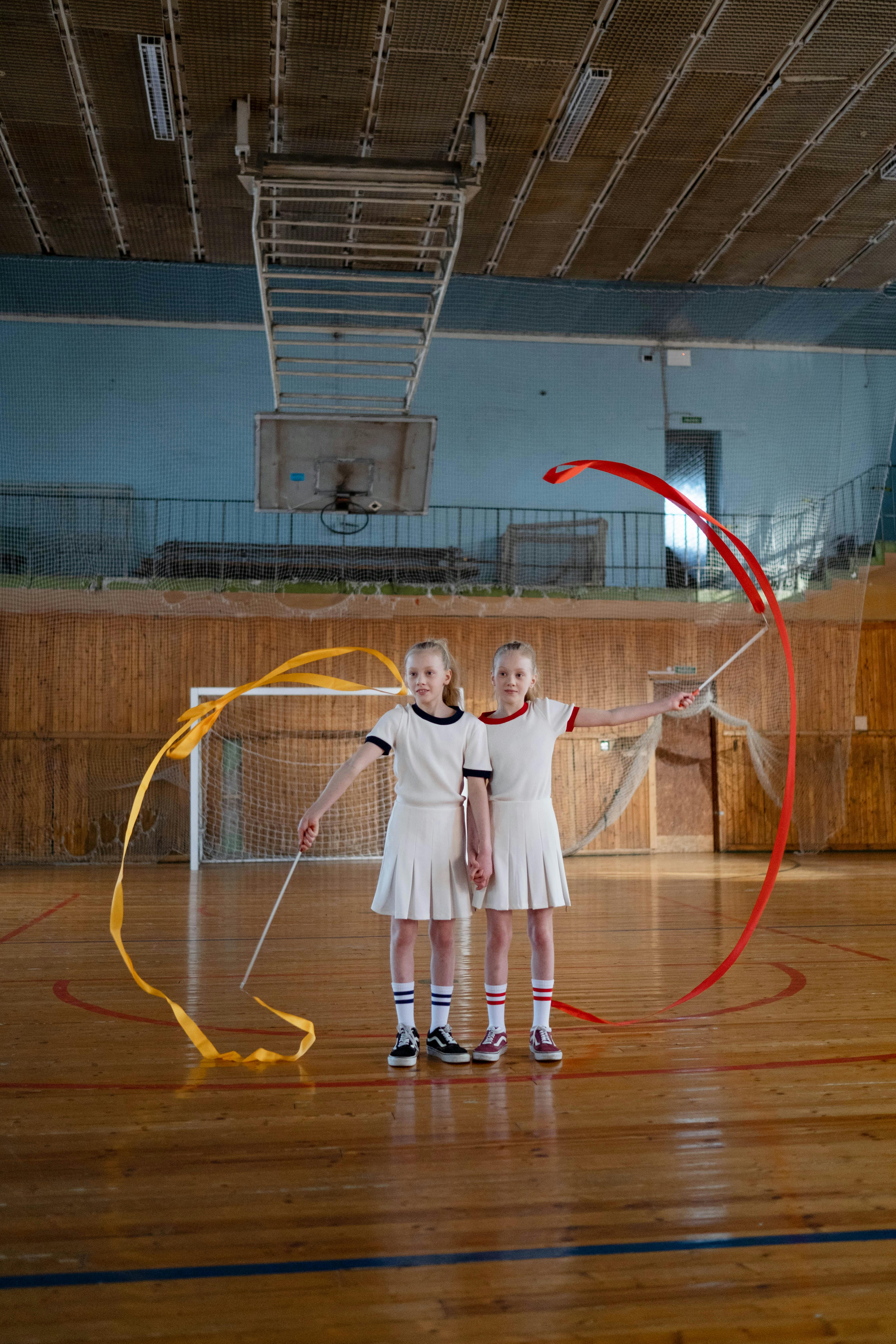 young girls standing together while holding ribbons