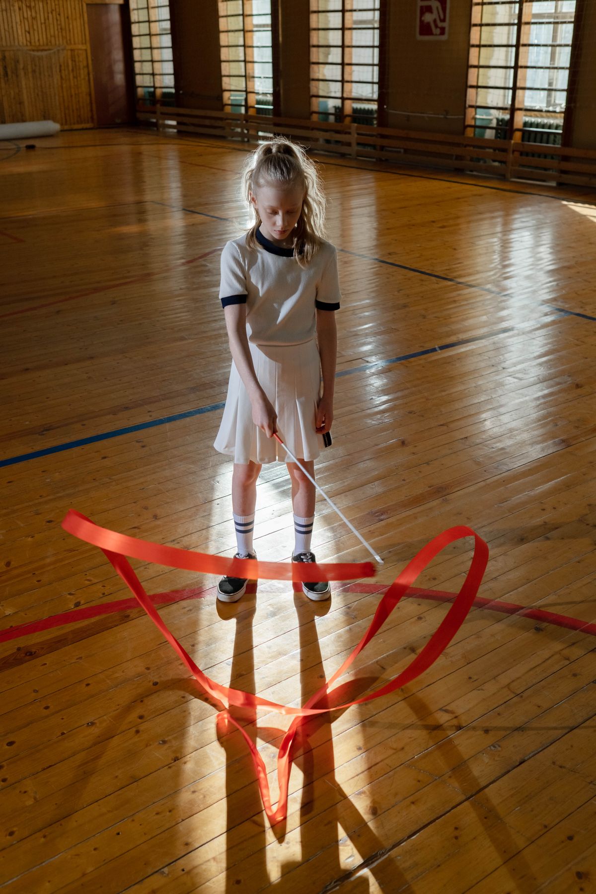 Niña practicando gimnasia rítmica con cinta y maillot