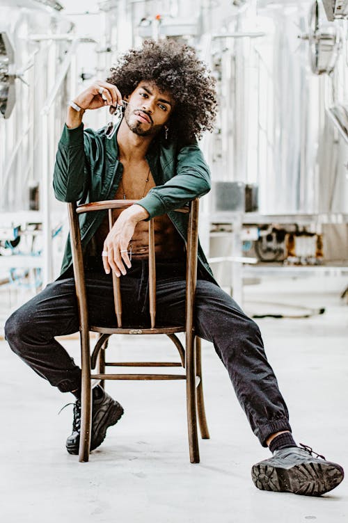 Man Sitting on Brown Wooden Chair