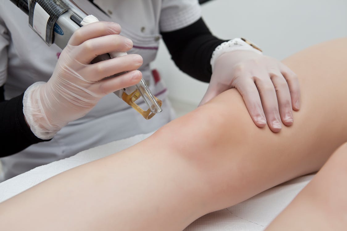 Free Person Performing a Skin Treatment Procedure Stock Photo