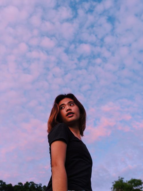 Free A serene portrait of a woman against a pink and blue sky, captured in MIMAROPA, Philippines. Stock Photo