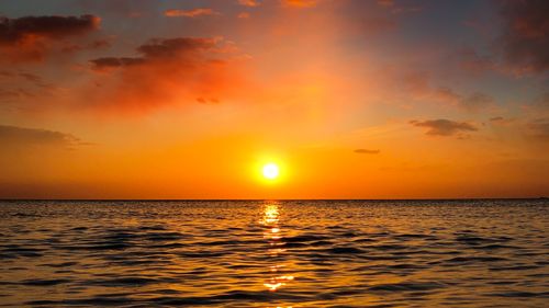 Free Breathtaking sunset over the ocean with vibrant orange and yellow hues. Stock Photo
