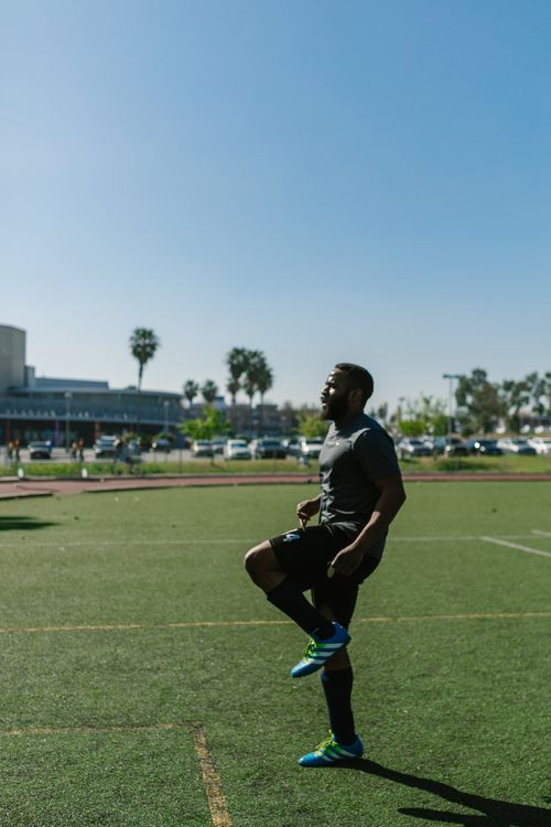 Free An athlete warms up on a sunlit soccer field, preparing for outdoor training. Stock Photo