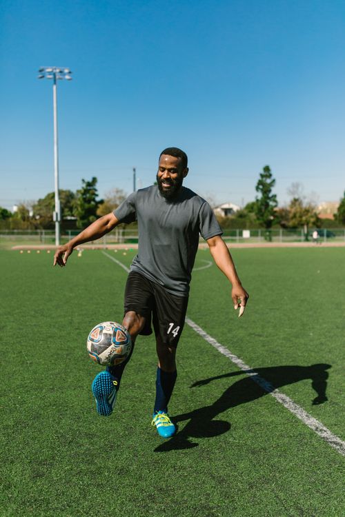 Free A man enjoying a casual soccer practice on a sunny day at a field. Stock Photo