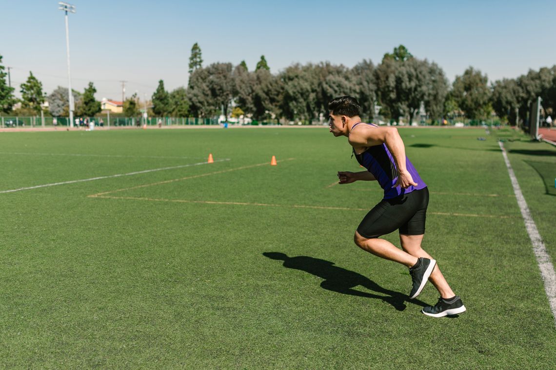 Male athlete beginning a run on a training field