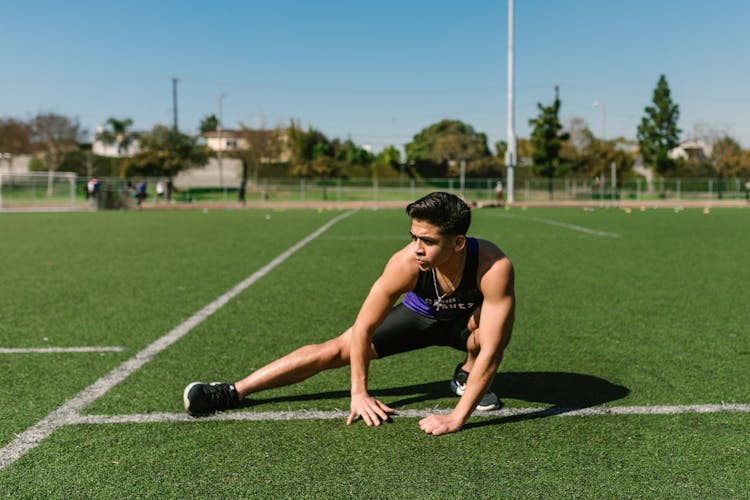 Young Man In Black Tights Stretching Legs