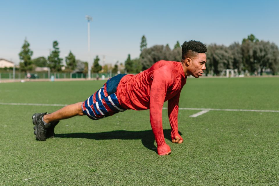 Athlete doing press-ups on grass