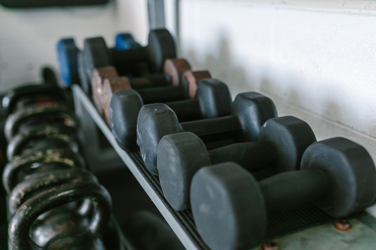 Dumbbells and kettlebells arranged on gym racks for strength training