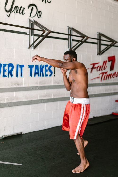 Free Boxer practicing punch technique inside a gym, embodying focus and strength. Stock Photo