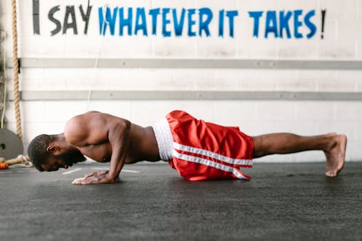 Athletic man doing push-ups indoors with motivational text.