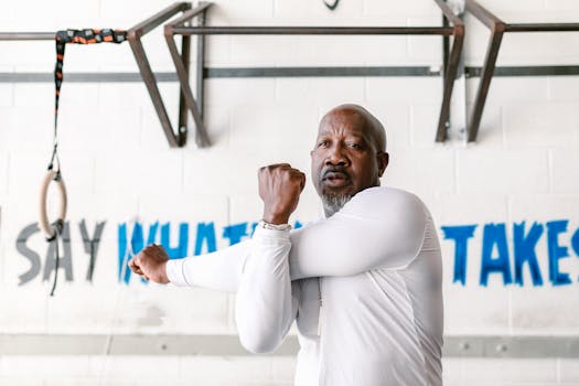 A middle-aged African American man stretching in a gym, emphasizing fitness and wellness.