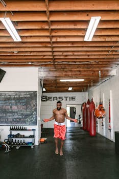 Athletic man working out with jump rope in an industrial-style gym. Perfect for fitness themes.