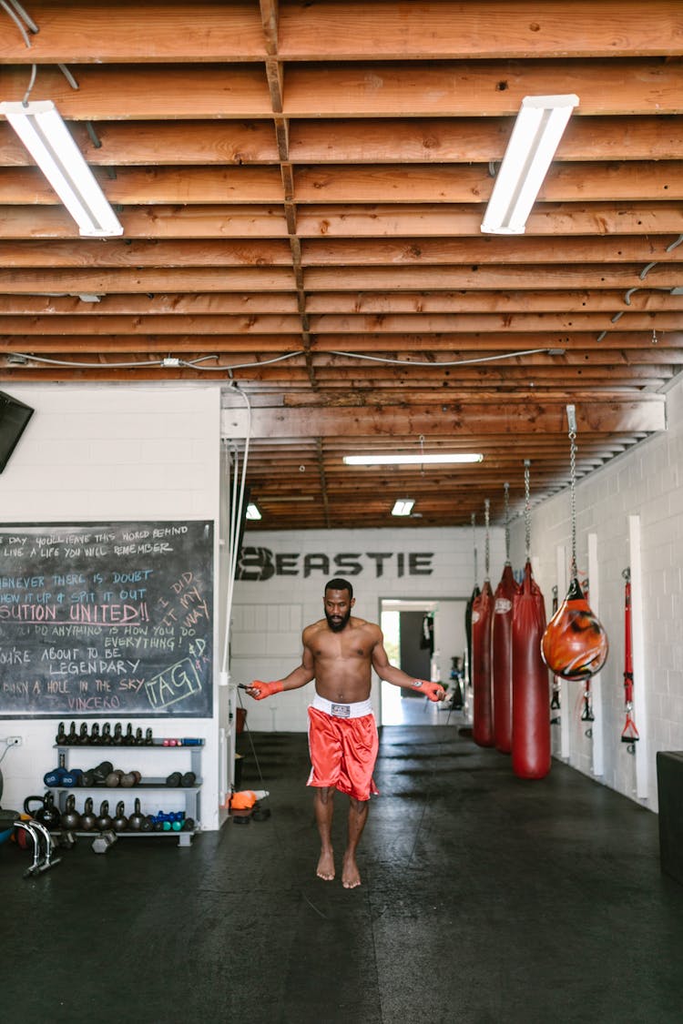 Shirtless Man In Red Shorts Training Using Jumping Rope