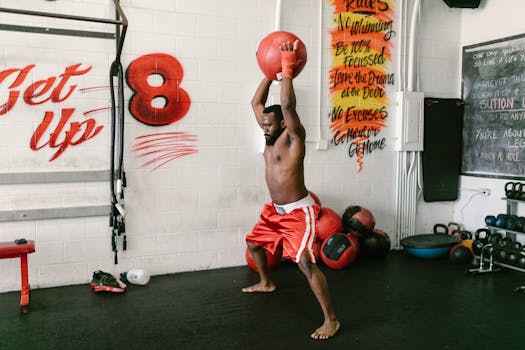 Athlete intensely training in a gym with a medicine ball, expressing strength and focus.