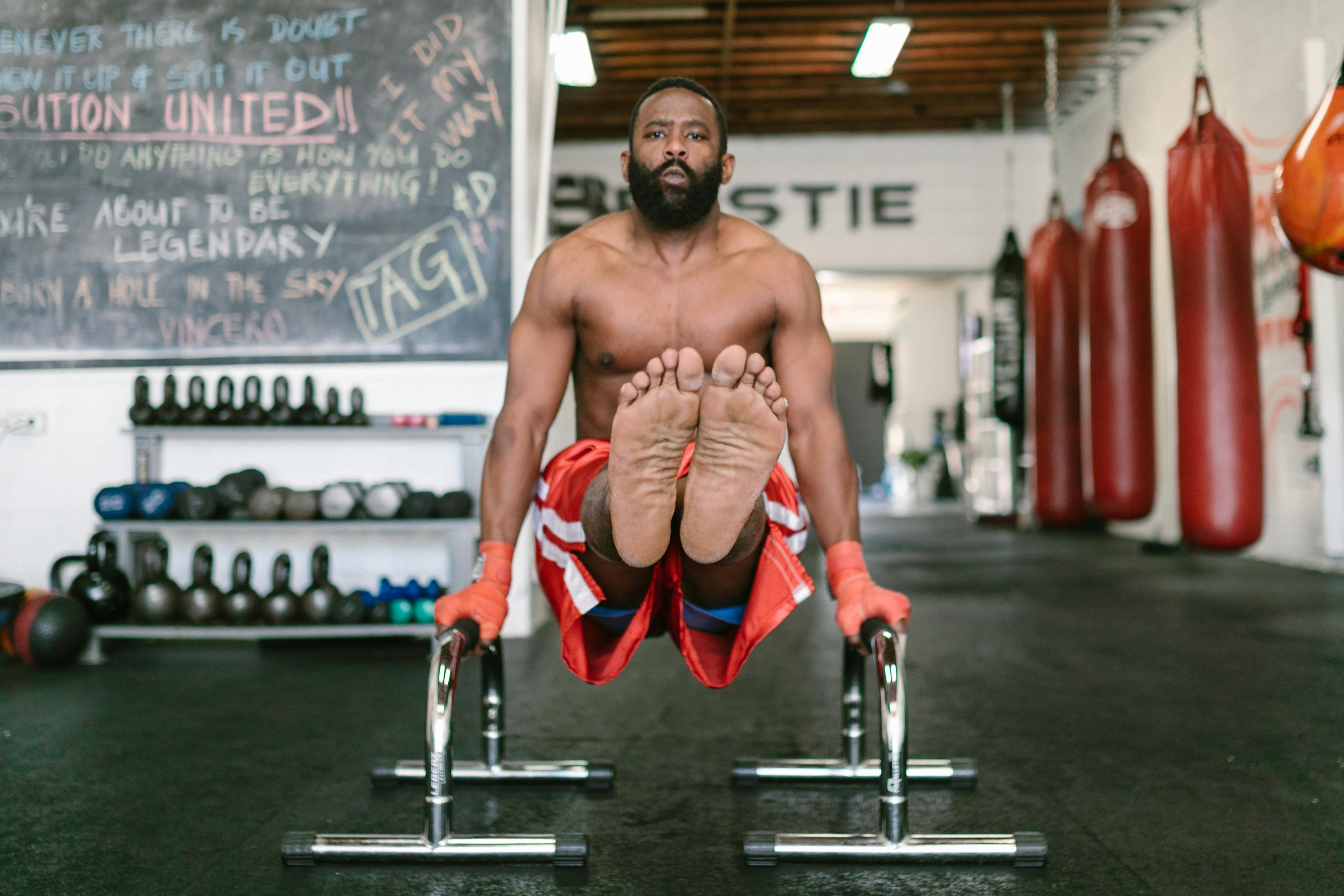 A Man Doing a Leg Raise on a Dip Bar Free Stock Photo