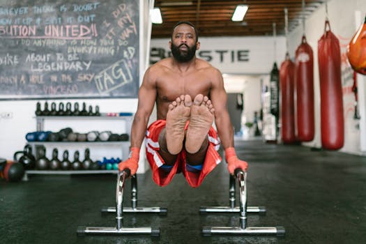 Fit man demonstrating strength and balance by exercising on parallel bars inside a gym.