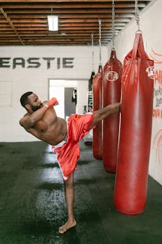 A fit man practices kickboxing in a gym, focusing on strength. Perfect for fitness themes.