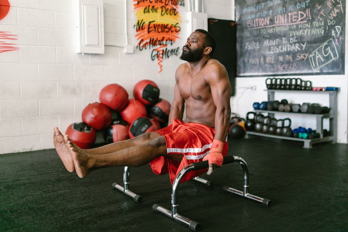 Brawny man performing calisthenics bodyweight exercises during a workout