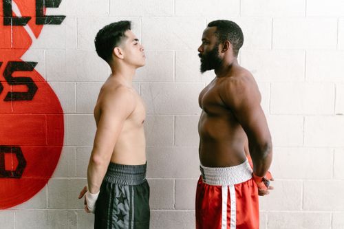Free Two muscular boxers standing face-to-face in a gym, showcasing strength and determination. Stock Photo